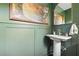 Chic green powder room with pedestal sink, large mirror, and elegant decor at 639 W Ponce De Leon Ave, Decatur, GA 30030