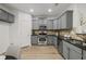 Well-lit kitchen boasts stainless steel appliances, gray cabinets, and granite countertops at 863 Commonwealth Se Ave, Atlanta, GA 30312