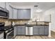 Modern kitchen featuring stainless steel appliances, granite countertops, and gray cabinets at 863 Commonwealth Se Ave, Atlanta, GA 30312