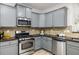Kitchen featuring stainless steel appliances, gray cabinets, and decorative backsplash at 863 Commonwealth Se Ave, Atlanta, GA 30312