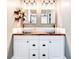 Stylish bathroom features a double sink vanity with white vessel sinks, wood countertop, and modern light fixtures at 1426 Memorial Se Dr, Atlanta, GA 30317