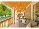 Relax on this cozy front porch with a wooden ceiling, space for seating, and view of the green lawn at 1426 Memorial Se Dr, Atlanta, GA 30317