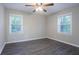 This bright bedroom features a ceiling fan, hardwood floors, and two windows with tree views at 2046 Copperfield Cir, Decatur, GA 30035