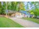 Charming two-story home with a red front door, a carport, a spacious front yard and a concrete driveway at 2046 Copperfield Cir, Decatur, GA 30035