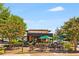 Outdoor seating area at a Starbucks coffee shop with lush green landscaping, umbrellas, and shade trees at 2316 Echelon Ln, Smyrna, GA 30080