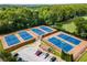 Overhead view of community tennis courts with players, parking, and mature tree landscaping that is surrounded by a fence at 2316 Echelon Ln, Smyrna, GA 30080