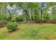 A well-maintained backyard featuring a lush green lawn surrounded by a wooden fence and mature trees at 2864 White Oak Dr, Decatur, GA 30032