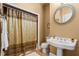 Bathroom featuring a pedestal sink, decorative mirror, and shower with patterned curtain at 1169 Dawn View Nw Ln, Atlanta, GA 30327