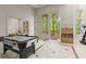 Air hockey table in bonus room with a view to the outside through large windows at 1169 Dawn View Nw Ln, Atlanta, GA 30327