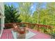 This deck has ample seating, red painted floors, and a wooded backyard view at 1169 Dawn View Nw Ln, Atlanta, GA 30327