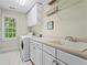 Bright laundry room with modern washer and dryer, white cabinets, and tile flooring at 1169 Dawn View Nw Ln, Atlanta, GA 30327