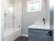 Bathroom featuring a tub with glass shower door, a modern vanity with storage space, and neutral paint at 246 Garland Ave, Decatur, GA 30030
