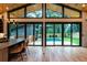 Modern living room featuring a wood ceiling, hardwood floors, and expansive sliding glass doors to the pool at 246 Garland Ave, Decatur, GA 30030