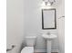 Well-lit bathroom with modern fixtures including a pedestal sink and a toilet at 4150 Cedar Bridge Walk, Suwanee, GA 30024