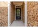 Inviting entryway with a sleek black door and classic brick surround at 4150 Cedar Bridge Walk, Suwanee, GA 30024