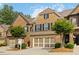 Charming brick townhome with a two-car garage and manicured landscaping on a sunny day at 4150 Cedar Bridge Walk, Suwanee, GA 30024