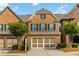 Lovely brick townhome featuring a two-car garage and a neatly landscaped front yard at 4150 Cedar Bridge Walk, Suwanee, GA 30024