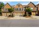 Beautiful brick townhome featuring a two-car garage and a meticulously maintained front yard at 4150 Cedar Bridge Walk, Suwanee, GA 30024