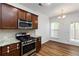 Open-concept kitchen featuring stainless steel appliances, granite countertops, and hardwood floors at 4150 Cedar Bridge Walk, Suwanee, GA 30024