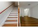 Elegant staircase with hardwood steps leading to an open area with sleek flooring at 4150 Cedar Bridge Walk, Suwanee, GA 30024