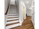 Elegant stairway with wood treads and handrail, contrasting white risers, and hardwood flooring at 4150 Cedar Bridge Walk, Suwanee, GA 30024