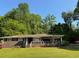 Brick home with a covered front porch and lush green lawn surrounded by mature trees at 4416 Arcadia Dr, Norcross, GA 30093