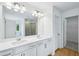 Bathroom features double sink vanity, large mirror and entrance to shower at 5377 Heron Bay Blvd, Locust Grove, GA 30248