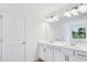 Bright bathroom featuring a double sink vanity, mirror, and door to a closet at 5377 Heron Bay Blvd, Locust Grove, GA 30248