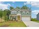 Charming two-story home features a stone and siding exterior, attached two-car garage, and well-manicured lawn at 5377 Heron Bay Blvd, Locust Grove, GA 30248