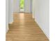 Hallway with hardwood floors and white walls leading to a view of the bright backyard at 5377 Heron Bay Blvd, Locust Grove, GA 30248