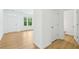 Hallway with hardwood floors and white walls leading to the door, living room, and a half-bathroom at 5377 Heron Bay Blvd, Locust Grove, GA 30248