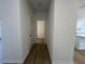 Hallway with hardwood floors leading to a kitchen, white walls and white trim at 5377 Heron Bay Blvd, Locust Grove, GA 30248