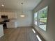 Open-concept kitchen with white cabinets, hardwood floors, stainless steel appliances, and a view of the backyard at 5377 Heron Bay Blvd, Locust Grove, GA 30248