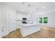 Bright kitchen featuring an island with a sink, stainless steel appliances, and white cabinets at 5377 Heron Bay Blvd, Locust Grove, GA 30248