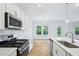 Updated kitchen with stainless steel appliances, white cabinets, and an island with sink at 5377 Heron Bay Blvd, Locust Grove, GA 30248