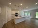 Modern kitchen with an island, white cabinets, pendant lighting, stainless steel appliances and hardwood floors at 5377 Heron Bay Blvd, Locust Grove, GA 30248