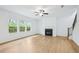 Living room featuring a fireplace, staircase, and large windows with natural light at 5377 Heron Bay Blvd, Locust Grove, GA 30248