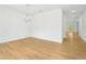 Bright living room with hardwood floors, white walls, modern chandelier, and view into hallway at 5377 Heron Bay Blvd, Locust Grove, GA 30248