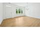 Bright living room with hardwood floors, white walls, modern chandelier, and large windows overlooking backyard at 5377 Heron Bay Blvd, Locust Grove, GA 30248