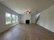 Spacious living room with hardwood floors, fireplace, fan, and large windows offering natural light at 5377 Heron Bay Blvd, Locust Grove, GA 30248
