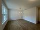 Bright and spacious living room featuring new hardwood floors, a chandelier, and large windows for natural light at 5377 Heron Bay Blvd, Locust Grove, GA 30248