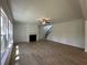 Bright living room featuring a fireplace, modern ceiling fan, and wood-look floors next to the staircase at 5377 Heron Bay Blvd, Locust Grove, GA 30248