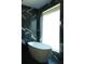 Modern bathtub sitting against black marble wall and window at 1921 Herbert Dr, Tucker, GA 30084
