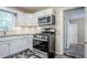 Well-appointed kitchen with white cabinets, modern stainless steel appliances, and unique backsplash at 2529 Habersham Dr, Decatur, GA 30032