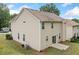 A two-story tan house featuring a sliding glass door, concrete patio and AC unit at 4405 Feather Way, Douglasville, GA 30135