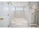 Bathroom features a large soaking tub next to an enclosed shower with gold hardware at 4405 Feather Way, Douglasville, GA 30135