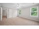 A carpeted bedroom showcasing two windows, neutral walls, ceiling fan, and doorways at 4405 Feather Way, Douglasville, GA 30135