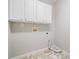 Bright laundry room with white cabinets, flooring, and neutral walls and fixtures at 4405 Feather Way, Douglasville, GA 30135