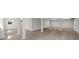 Bright, open basement area with updated flooring, support beams, and a doorway to the outside at 7300 Wynhill Dr, Sandy Springs, GA 30328