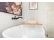 Close-up of soaking tub with bamboo caddy, wine glass and view to shower in updated bathroom at 7300 Wynhill Dr, Sandy Springs, GA 30328